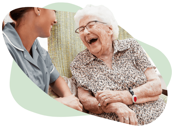 elderly woman laughing to carer