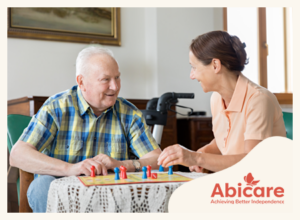 elderly person and carer playing board game