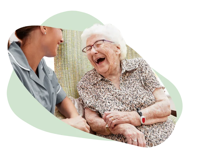 elderly woman laughing with carer