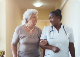 carer linking arms with elderly woman