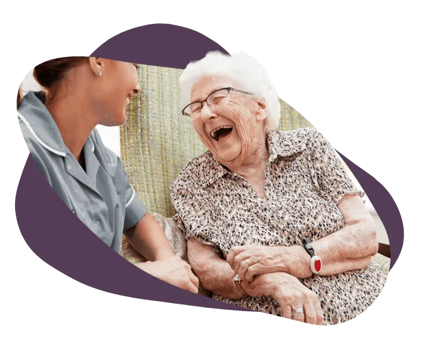 elderly woman laughing to carer